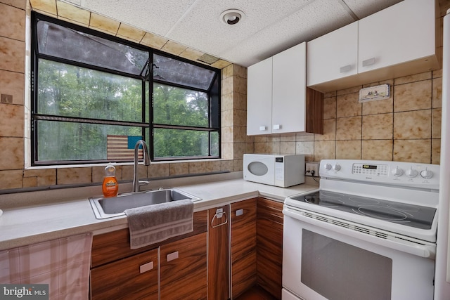 3962 Bensalem Blvd, Bensalem, PA 19020 - kitchen with white appliances, a sink, light countertops, white cabinets, and backsplash