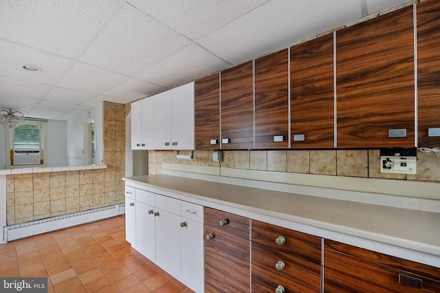 3962 Bensalem Blvd, Bensalem, PA 19020 - kitchen with a baseboard heating unit, a paneled ceiling, light countertops, white cabinets, and cooling unit