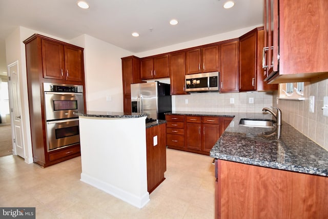 11665 Leesborough Cir, Silver Spring, MD 20902 - kitchen with appliances with stainless steel finishes, a sink, dark stone countertops, a center island, and tasteful backsplash