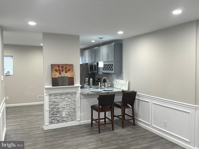 1165 Atwood Rd, Philadelphia, PA 19151 - kitchen featuring recessed lighting, dark wood-type flooring, gray cabinets, a kitchen breakfast bar, and decorative backsplash