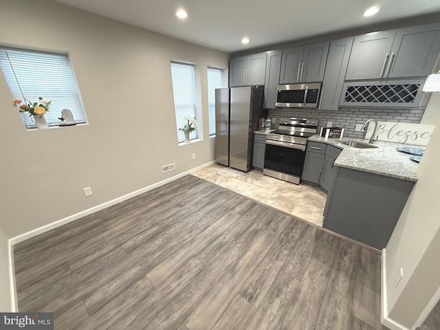 1165 Atwood Rd, Philadelphia, PA 19151 - kitchen featuring appliances with stainless steel finishes, a sink, light wood-style floors, backsplash, and gray cabinets