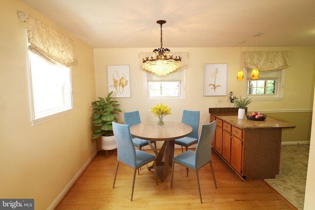 4801 Oxbow Rd, Rockville, MD 20852 - dining room with plenty of natural light, a chandelier, light wood finished floors, and baseboards