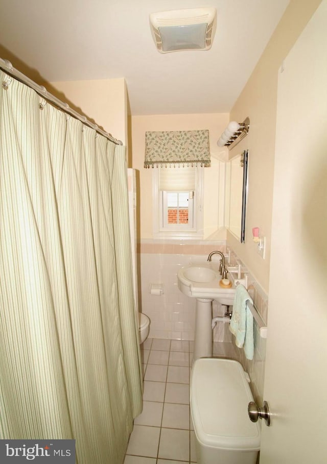 4801 Oxbow Rd, Rockville, MD 20852 - full bathroom featuring toilet, tile walls, tile patterned floors, a shower with shower curtain, and wainscoting