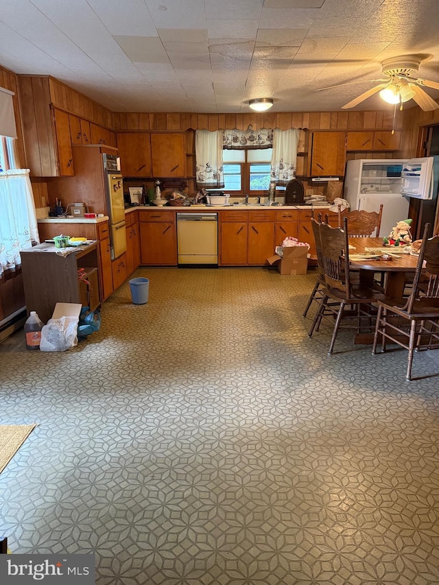 81 Hollering Hill Rd, Camden Wyoming, DE 19934 - kitchen with dishwasher, wood walls, a warming drawer, brown cabinetry, and light countertops