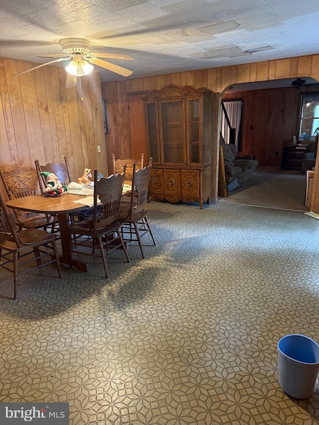 81 Hollering Hill Rd, Camden Wyoming, DE 19934 - dining area with wooden walls, arched walkways, stairway, and ceiling fan