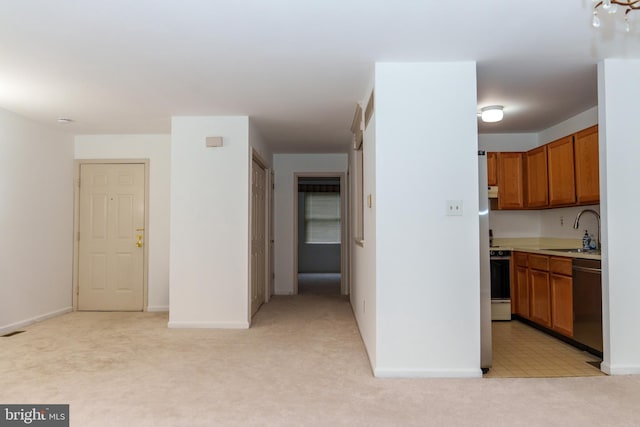 355 Norris Hall Ln Unit 355, Jeffersonville, PA 19403 - kitchen featuring dishwashing machine, light carpet, a sink, brown cabinets, and light countertops
