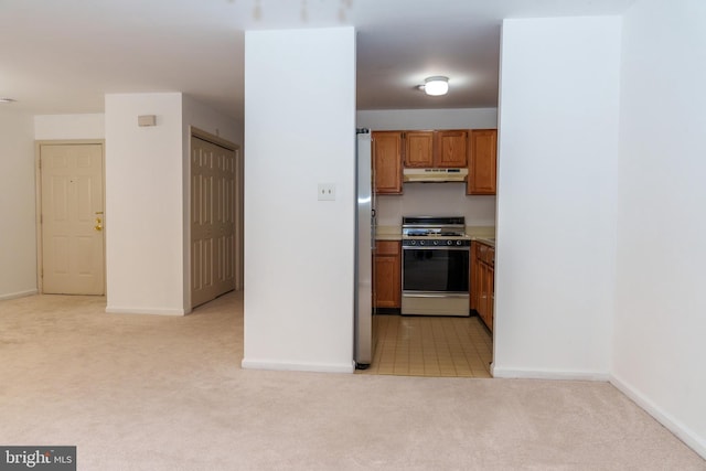 355 Norris Hall Ln Unit 355, Jeffersonville, PA 19403 - kitchen featuring range with gas stovetop, under cabinet range hood, light carpet, brown cabinetry, and freestanding refrigerator