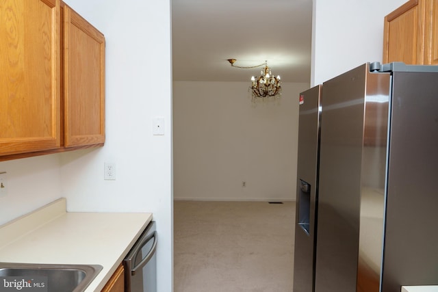 355 Norris Hall Ln Unit 355, Jeffersonville, PA 19403 - kitchen featuring stainless steel appliances, light colored carpet, a chandelier, light countertops, and brown cabinetry