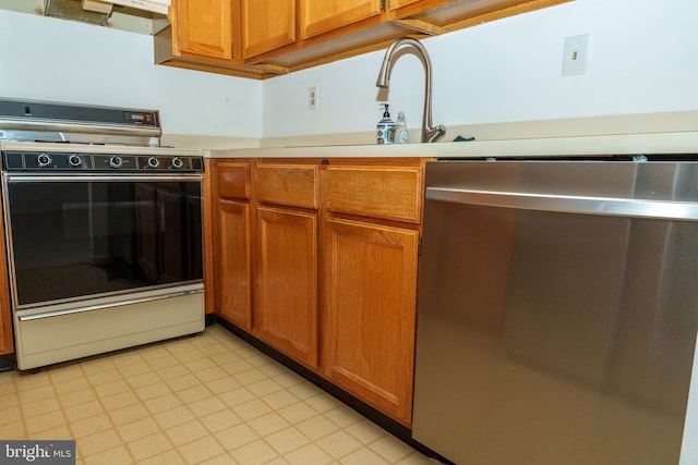 355 Norris Hall Ln Unit 355, Jeffersonville, PA 19403 - kitchen with electric range oven, dishwasher, light countertops, brown cabinetry, and a sink