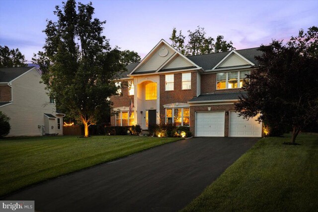 9308 Eagle Ct, Manassas Park, VA 20111 - view of front of house with a garage, asphalt driveway, a yard, and brick siding