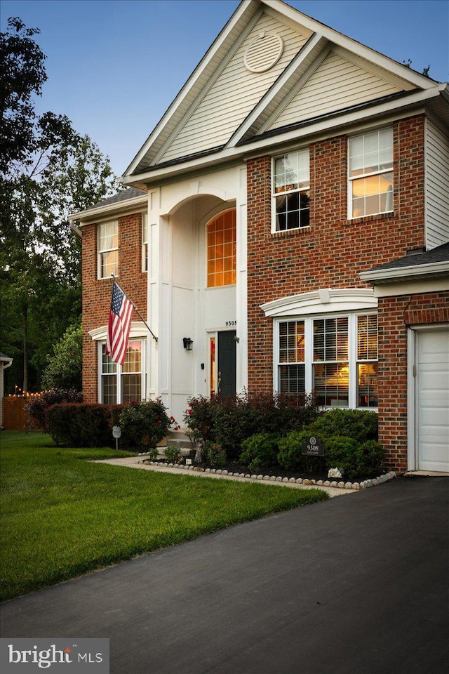 9308 Eagle Ct, Manassas Park, VA 20111 - view of front of property with brick siding, a front lawn, and a garage