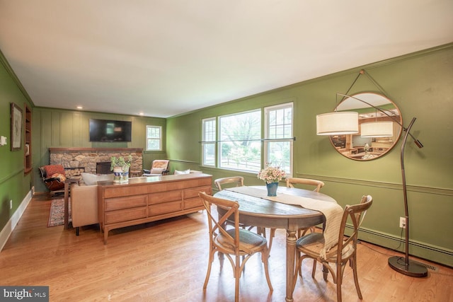 448 Old Dublin Pike, Doylestown, PA 18901 - dining room featuring a decorative wall, crown molding, light wood finished floors, a baseboard heating unit, and a fireplace