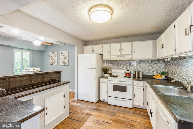 11833 Shire Ct Unit 12C, Reston, VA 20191 - kitchen with white appliances, under cabinet range hood, dark countertops, a sink, and a textured ceiling