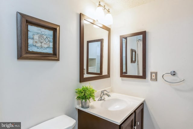11833 Shire Ct Unit 12C, Reston, VA 20191 - half bathroom featuring vanity, toilet, and a textured ceiling