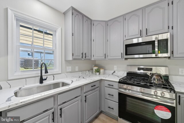 3521 Forestdale Ave, Woodbridge, VA 22193 - kitchen with appliances with stainless steel finishes, a sink, gray cabinetry, and light stone counters