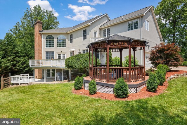 34905 Gidney Ct, Round Hill, VA 20141 - back of house with a gazebo, a chimney, stucco siding, a wooden deck, and a lawn