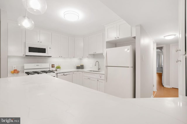 5041 7th Rd S Unit 102, Arlington, VA 22204 - kitchen with white appliances, a sink, white cabinetry, light stone counters, and backsplash
