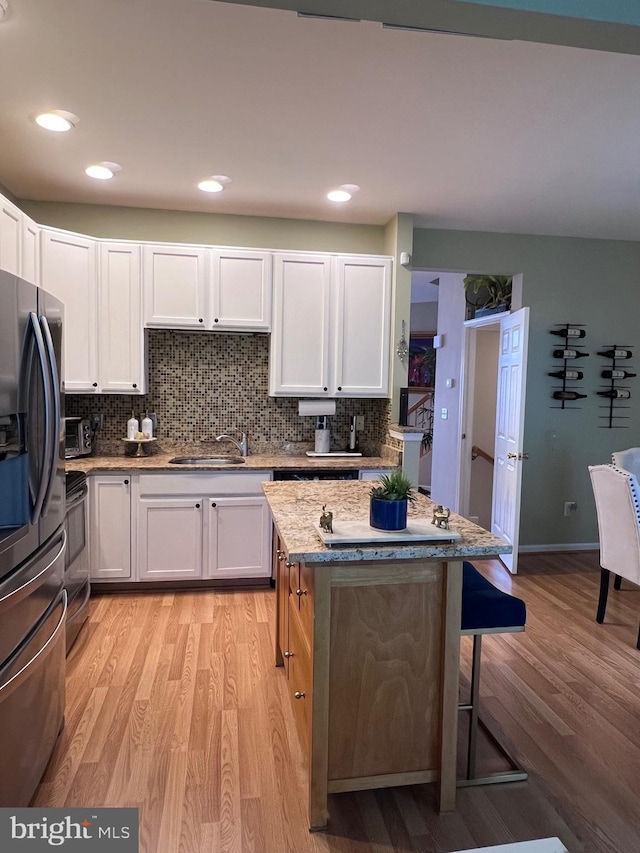7884 Seafarer Way, Lorton, VA 22079 - kitchen with stainless steel fridge with ice dispenser, stove, light wood-style floors, a breakfast bar area, and recessed lighting