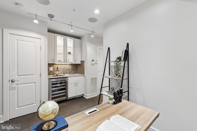 652 L St NE Unit 1, Washington, DC 20002 - bar featuring beverage cooler, tasteful backsplash, a sink, and baseboards