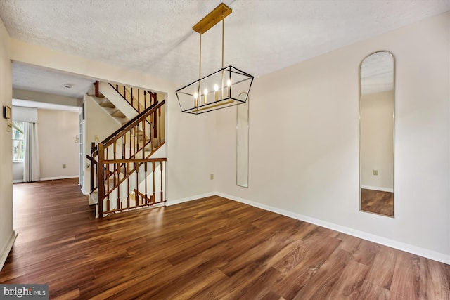 19256 Misty Meadow Ter, Germantown, MD 20874 - unfurnished dining area featuring wood finished floors, baseboards, stairway, a textured ceiling, and a chandelier