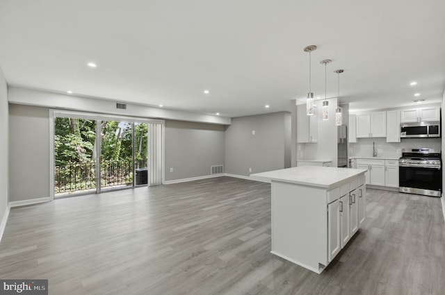 2310 Ewing Ave Unit 203, Suitland, MD 20746 - kitchen featuring appliances with stainless steel finishes, light wood-style flooring, open floor plan, light countertops, and recessed lighting