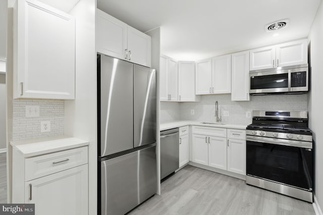 2310 Ewing Ave Unit 203, Suitland, MD 20746 - kitchen with appliances with stainless steel finishes, light countertops, light wood finished floors, and backsplash