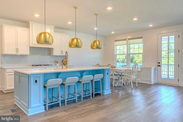 15634 Calum Ct, Haymarket, VA 20169 - kitchen with a sink, backsplash, light wood finished floors, white cabinetry, and recessed lighting