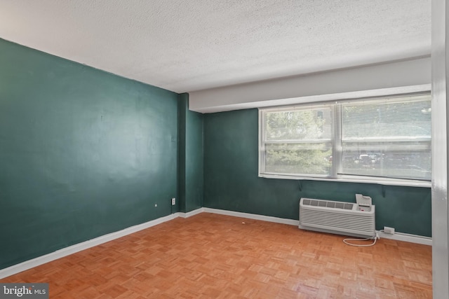 1801 Clydesdale Pl NW Unit 420, Washington, DC 20009 - spare room featuring a textured ceiling, a wall unit AC, and baseboards