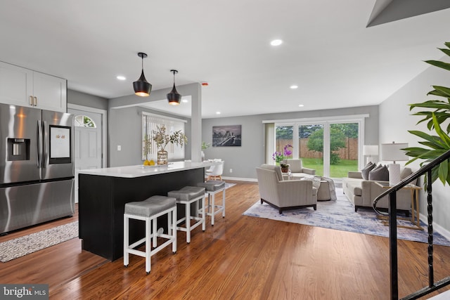3408 Croydon Rd, Gwynn Oak, MD 21207 - kitchen with stainless steel fridge with ice dispenser, a center island, wood finished floors, open floor plan, and a breakfast bar area