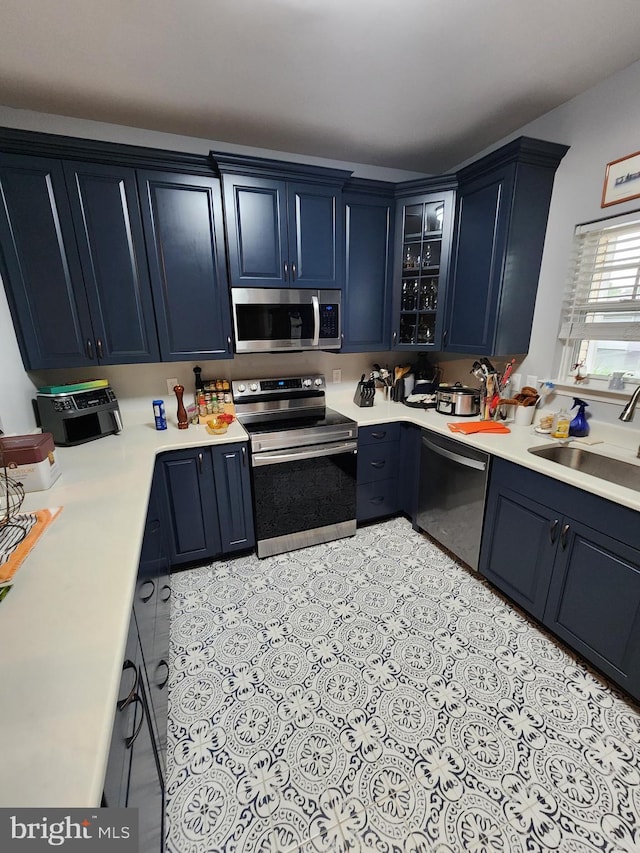 37484 Pettinaro Dr Unit 8300, Ocean View, DE 19970 - kitchen featuring appliances with stainless steel finishes, a sink, glass insert cabinets, light countertops, and blue cabinets