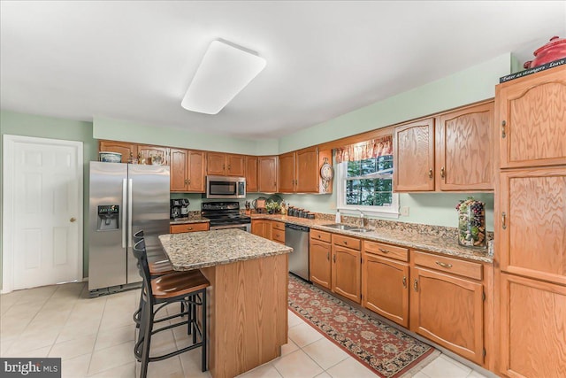 614 Timber Wood Blvd, Newark, DE 19702 - kitchen featuring stainless steel appliances, a kitchen island, a sink, light stone counters, and a breakfast bar