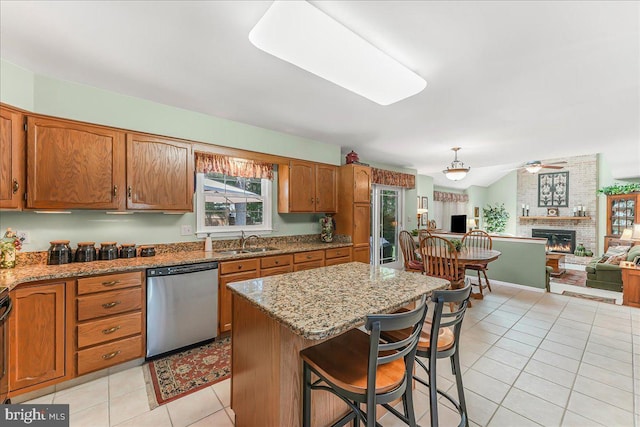 614 Timber Wood Blvd, Newark, DE 19702 - kitchen featuring stainless steel dishwasher, a sink, ceiling fan, light tile patterned floors, and a fireplace