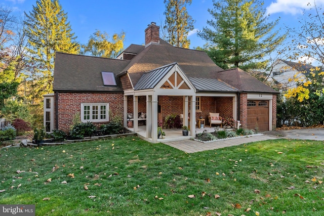 12 Chestnut Ln, Wayne, PA 19087 - rear view of property featuring brick siding, a garage, and a lawn