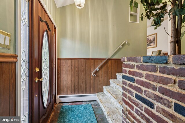 711 Pikeland Ave, Spring City, PA 19475 - foyer featuring a baseboard heating unit, a wainscoted wall, wood walls, and stairway