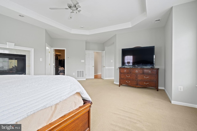10000 Umbrella Pl, Nokesville, VA 20181 - bedroom with light carpet, a tray ceiling, baseboards, crown molding, and a multi sided fireplace