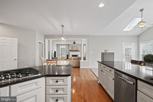 10000 Umbrella Pl, Nokesville, VA 20181 - kitchen with appliances with stainless steel finishes, ceiling fan, a skylight, a fireplace, and white cabinets