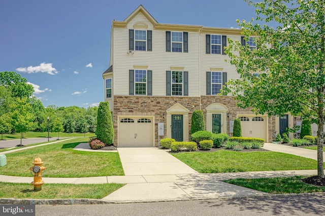 1 Village Green Ln, Sicklerville, NJ 08081 - townhome / multi-family property featuring driveway, an attached garage, a front lawn, and stone siding
