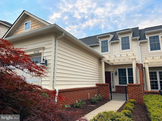 44324 Stableford Sq, Ashburn, VA 20147 - view of front of home featuring a gate, brick siding, and a pergola