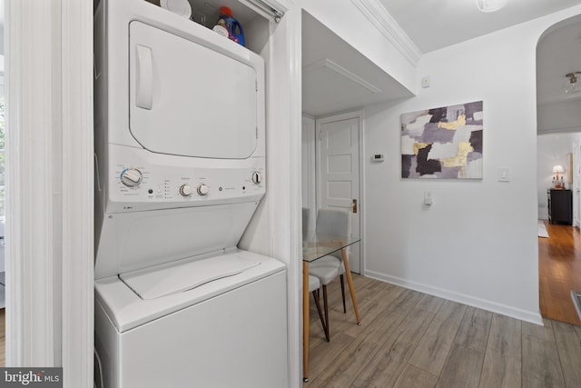 3 Russell Rd Unit 3B, Alexandria, VA 22301 - laundry area featuring stacked washing machine and dryer, wood finished floors, and arched walkways
