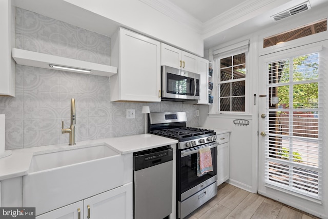 3 Russell Rd Unit 3B, Alexandria, VA 22301 - kitchen featuring appliances with stainless steel finishes, ornamental molding, open shelves, white cabinetry, and light countertops