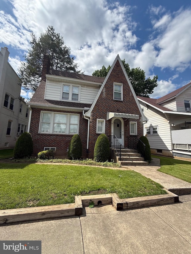 827 Pennsylvania Ave, York, PA 17404 - english style home with brick siding, a front lawn, and a chimney