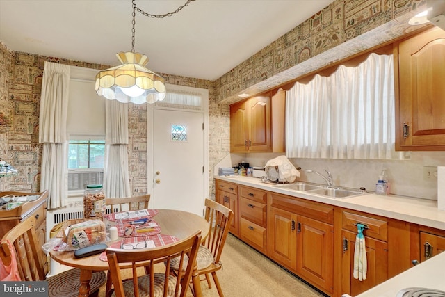 827 Pennsylvania Ave, York, PA 17404 - kitchen featuring a sink, light countertops, wallpapered walls, brown cabinets, and hanging light fixtures
