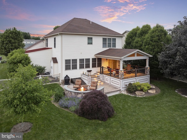 6133 Jennifer Ln, Spring Grove, PA 17362 - back of property at dusk with an outdoor fire pit, a deck, and roof with shingles