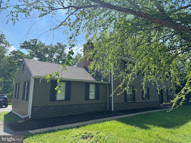 322 Wallace Dr, Newark, DE 19711 - view of property exterior with a lawn, roof with shingles, a chimney, and stone siding