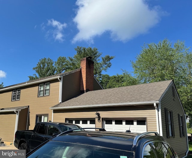 322 Wallace Dr, Newark, DE 19711 - view of side of property featuring a chimney, a garage, and roof with shingles