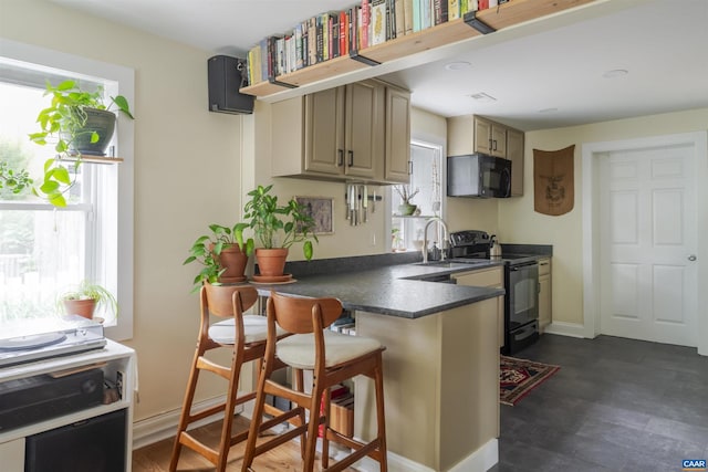 304 NW 11th St, Charlottesville, VA 22903 - kitchen with black appliances, a sink, dark countertops, a peninsula, and a kitchen breakfast bar