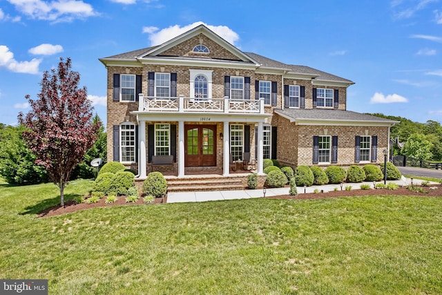 18604 Wild Raspberry Dr, Purcellville, VA 20132 - georgian-style home featuring brick siding, a balcony, a front lawn, french doors, and covered porch