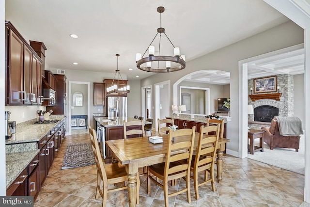 18604 Wild Raspberry Dr, Purcellville, VA 20132 - dining area featuring a chandelier, a fireplace, recessed lighting, arched walkways, and baseboards