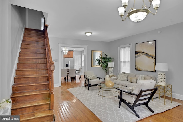 4316 9th St NW, Washington, DC 20011 - living room featuring a chandelier, stairway, light wood-type flooring, and baseboards