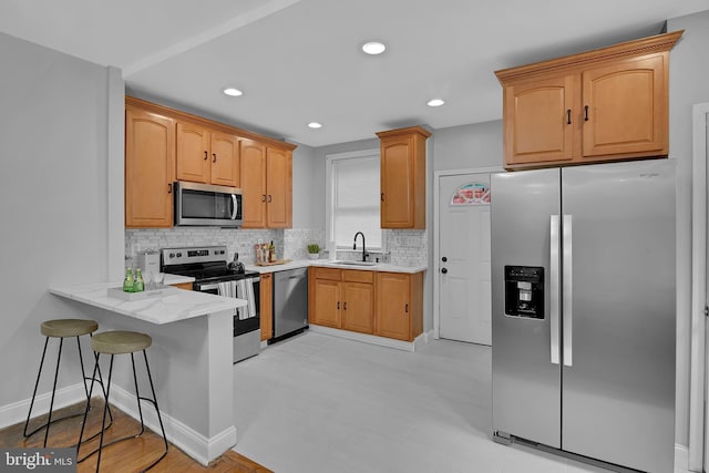 4316 9th St NW, Washington, DC 20011 - kitchen with stainless steel appliances, decorative backsplash, a peninsula, a sink, and a breakfast bar area